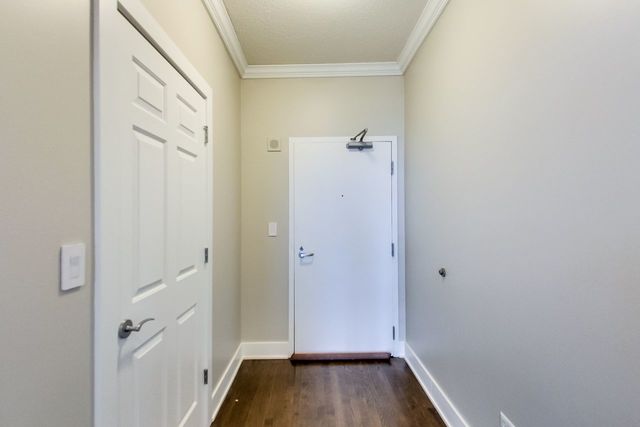 entryway with crown molding and dark hardwood / wood-style flooring