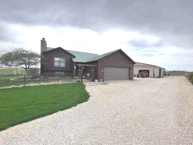 view of front of property with driveway, a garage, a chimney, fence, and a front yard