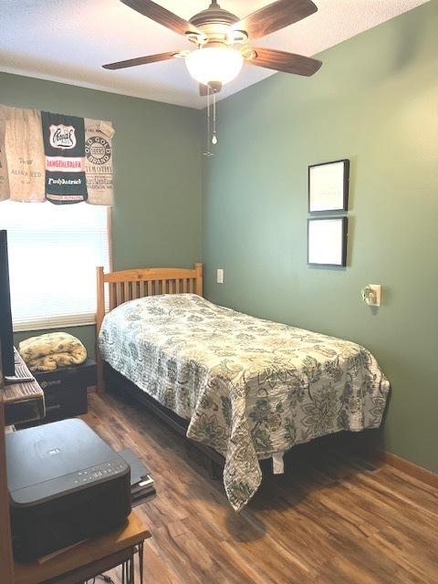 bedroom with baseboards, a ceiling fan, and wood finished floors