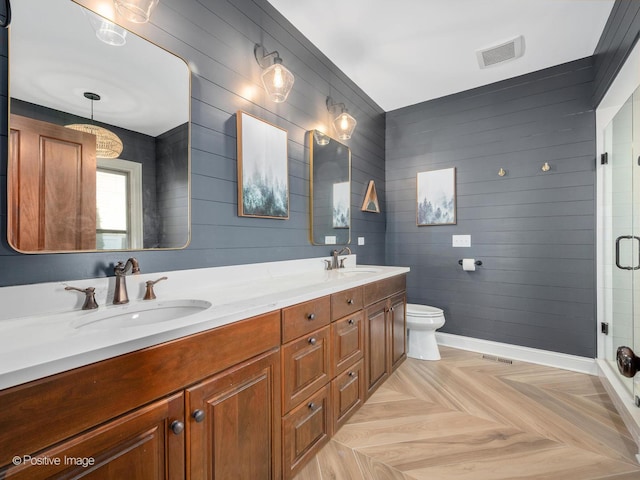 bathroom featuring walk in shower, parquet floors, vanity, and toilet