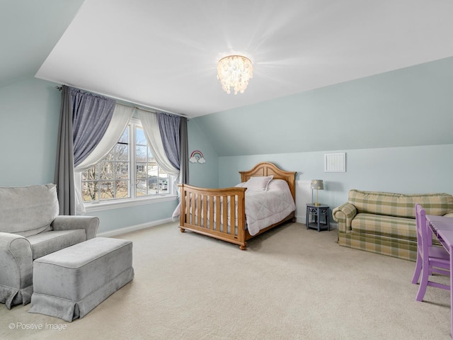 bedroom with lofted ceiling, a notable chandelier, and carpet