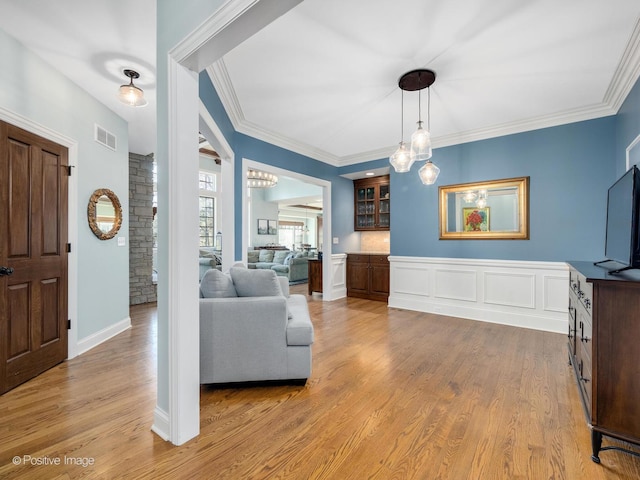 living room with ornamental molding and light hardwood / wood-style floors