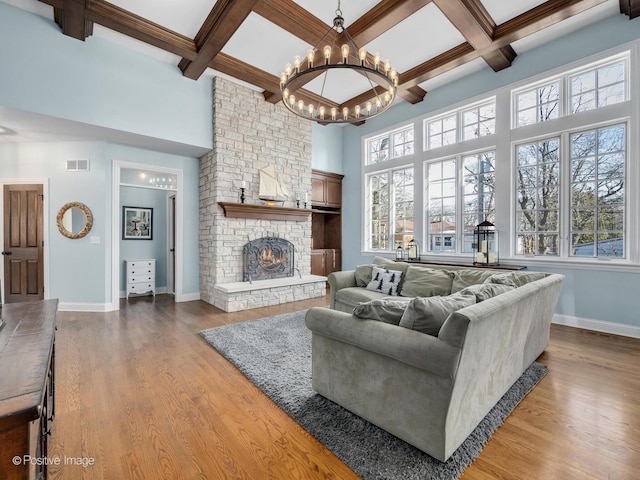 living room with hardwood / wood-style floors, a stone fireplace, and a wealth of natural light