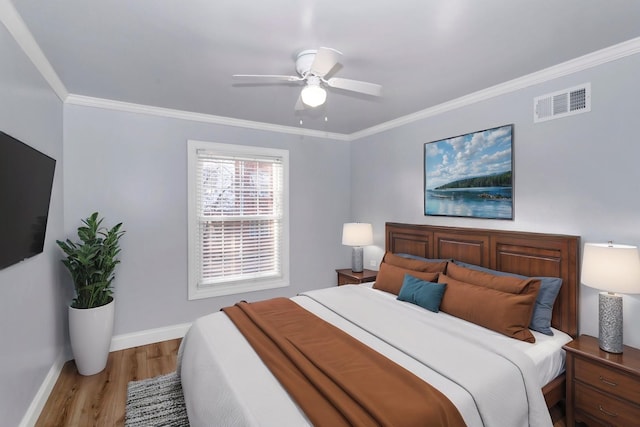 bedroom featuring ornamental molding, light hardwood / wood-style floors, and ceiling fan