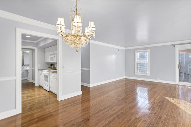 spare room with hardwood / wood-style flooring, ornamental molding, and a notable chandelier