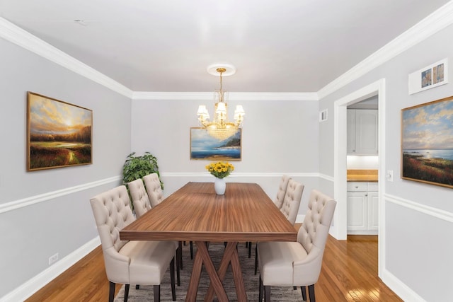 dining space with an inviting chandelier, wood-type flooring, and ornamental molding