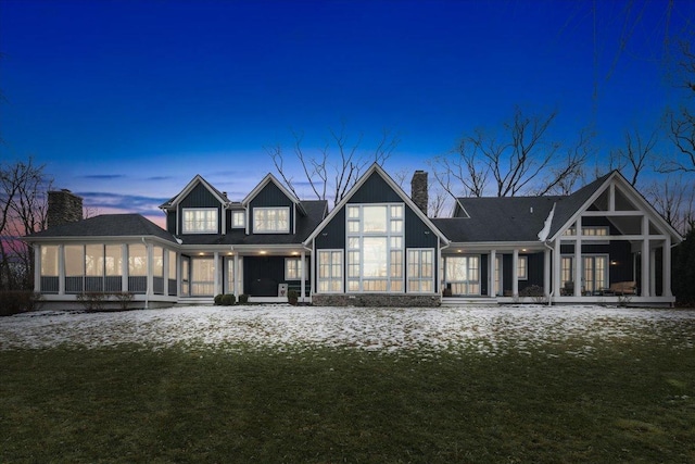 back of property featuring a sunroom and a chimney