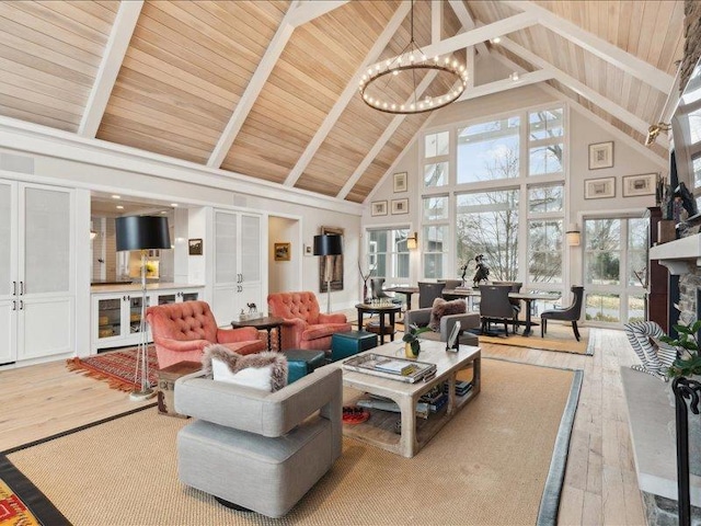 living room featuring a notable chandelier, a stone fireplace, wooden ceiling, beamed ceiling, and hardwood / wood-style floors