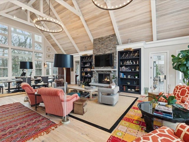 living area featuring a stone fireplace, wooden ceiling, wood finished floors, and a notable chandelier