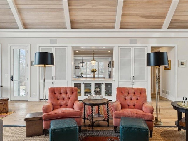 sitting room with vaulted ceiling with beams, wood ceiling, visible vents, and wood finished floors