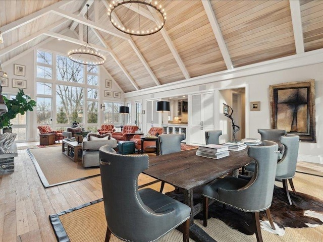 dining area featuring a chandelier, high vaulted ceiling, beamed ceiling, and wood-type flooring