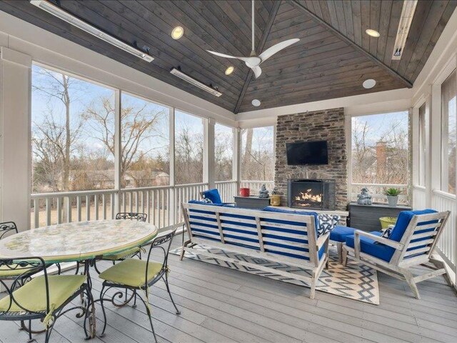 sunroom / solarium with lofted ceiling, an outdoor brick fireplace, wooden ceiling, and a ceiling fan