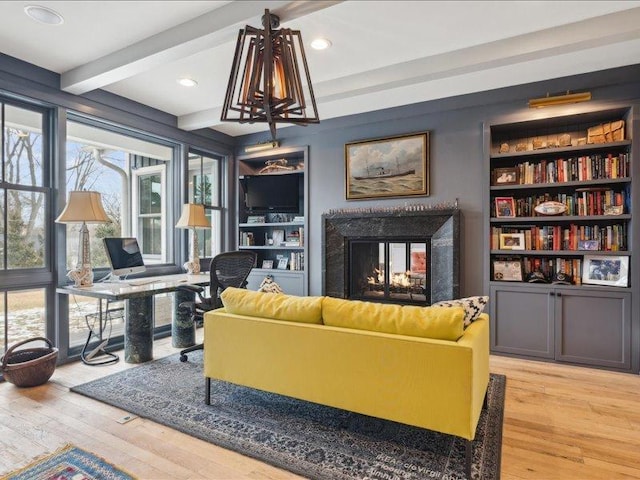 sitting room featuring beam ceiling, a multi sided fireplace, hardwood / wood-style flooring, and recessed lighting