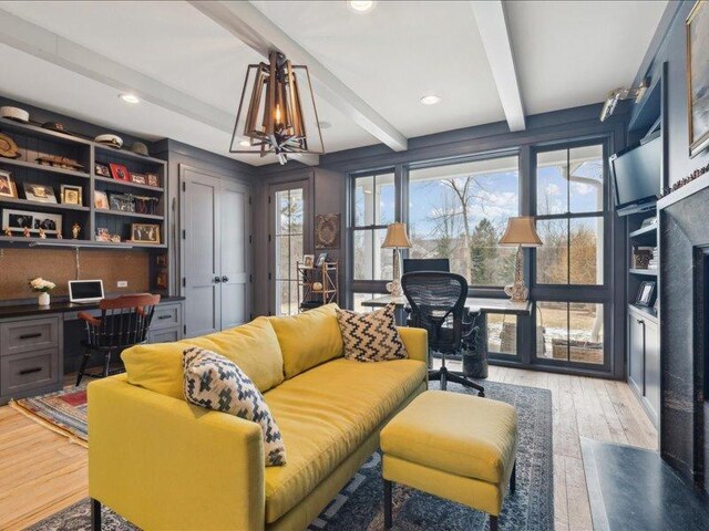 living room featuring built in desk, wood finished floors, a chandelier, beam ceiling, and recessed lighting