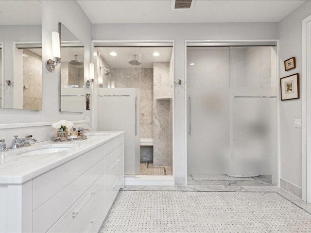 full bathroom with double vanity, visible vents, a sink, and tiled shower