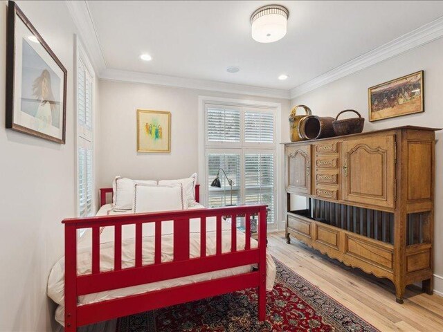 bedroom featuring ornamental molding, light wood-style flooring, and recessed lighting