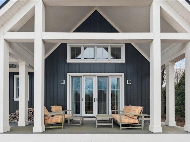 back of house featuring board and batten siding, french doors, and covered porch