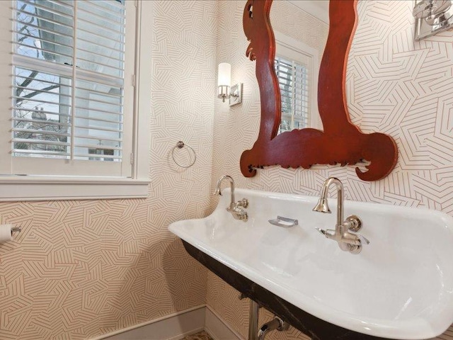 bathroom with a sink and wallpapered walls