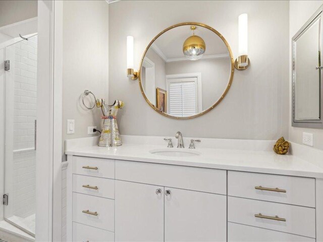 bathroom featuring a stall shower, crown molding, and vanity