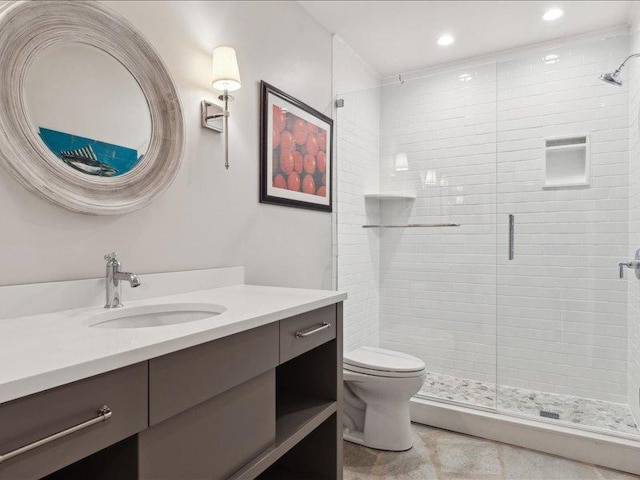 bathroom featuring a stall shower, vanity, and toilet