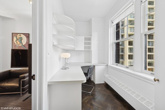 dining area with ornamental molding and dark parquet flooring