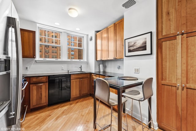 kitchen featuring appliances with stainless steel finishes, sink, and light hardwood / wood-style floors