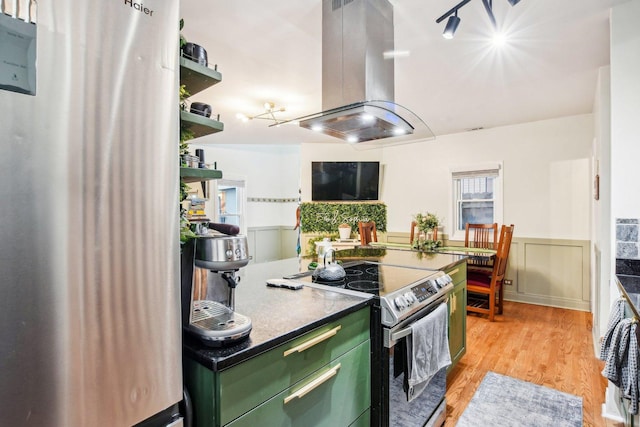 kitchen featuring fridge, island exhaust hood, light hardwood / wood-style floors, and stainless steel range with electric cooktop