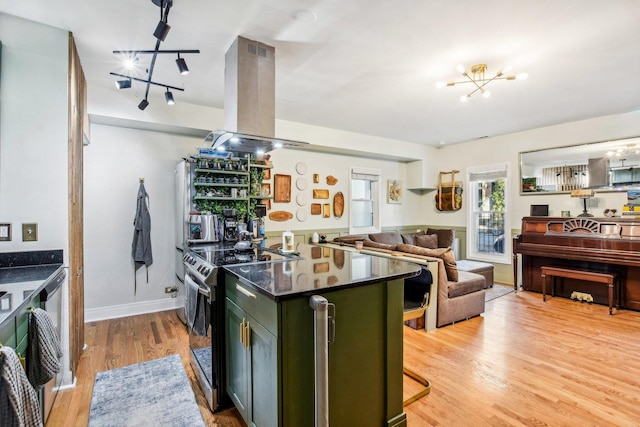 kitchen featuring electric stove, an inviting chandelier, green cabinetry, island exhaust hood, and light wood-type flooring