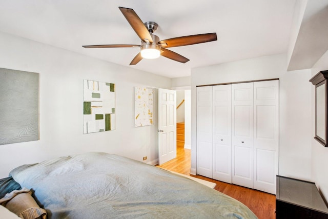 bedroom featuring light hardwood / wood-style floors, a closet, and ceiling fan