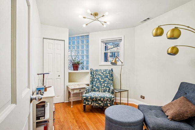 living area with hardwood / wood-style flooring and a notable chandelier