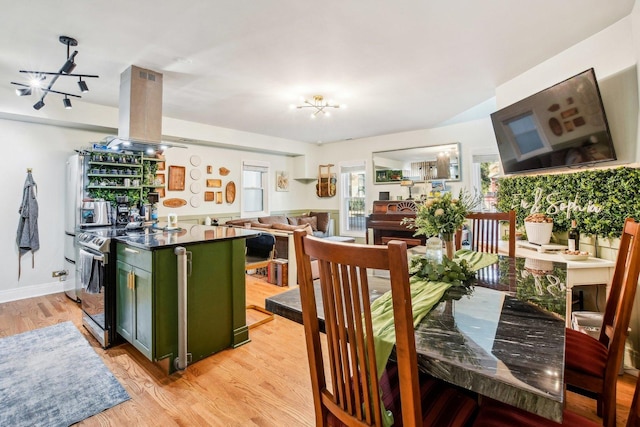 kitchen with electric stove, island range hood, green cabinetry, and light wood-type flooring