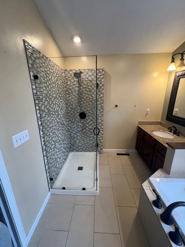 bathroom with tile patterned floors, vanity, and a tile shower