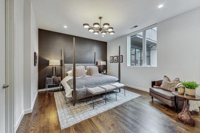 bedroom with an inviting chandelier and dark wood-type flooring