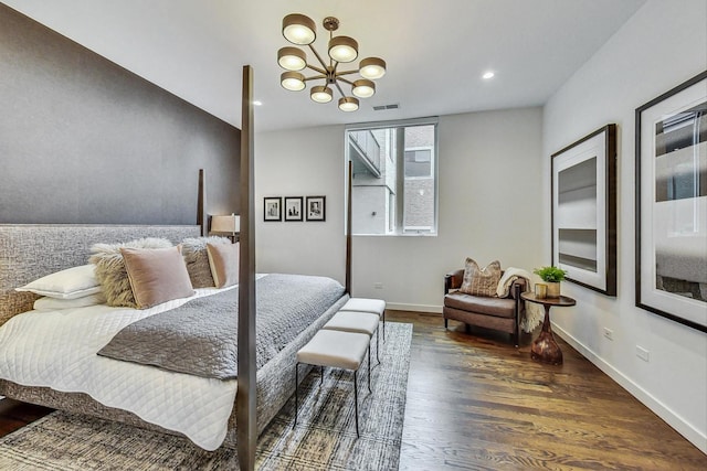 bedroom with an inviting chandelier and dark hardwood / wood-style floors