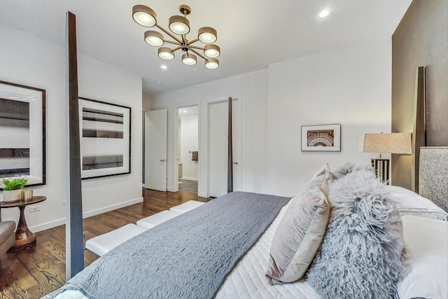 bedroom featuring an inviting chandelier and dark hardwood / wood-style floors