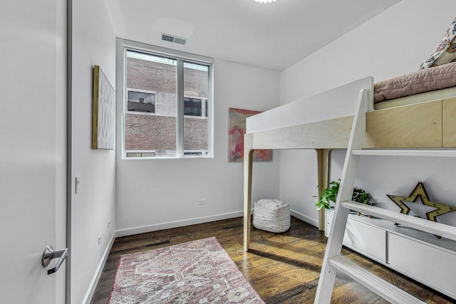 bedroom with dark hardwood / wood-style floors