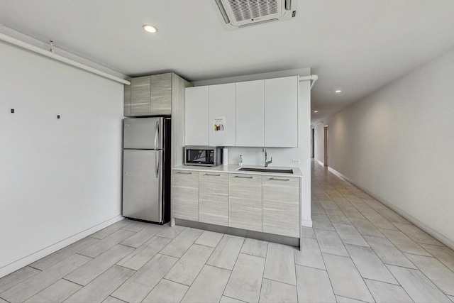 kitchen featuring appliances with stainless steel finishes, sink, and white cabinets