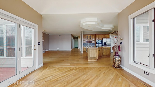 kitchen with decorative backsplash, appliances with stainless steel finishes, and light wood-type flooring