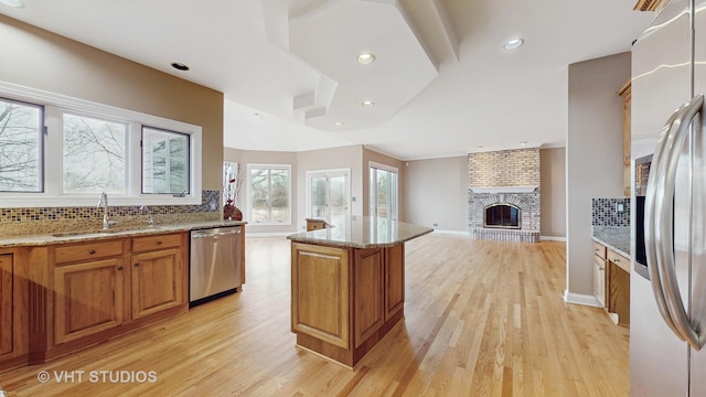 kitchen featuring appliances with stainless steel finishes, a center island, sink, and decorative backsplash