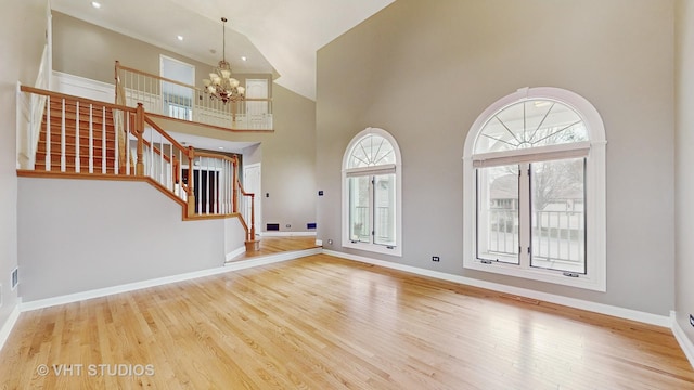 entryway featuring wood-type flooring, a chandelier, and a high ceiling