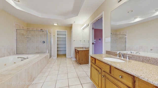 bathroom with a raised ceiling, vanity, tile patterned floors, and plus walk in shower