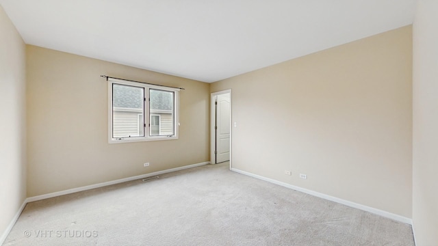 unfurnished room featuring light carpet