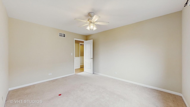 empty room featuring light colored carpet and ceiling fan