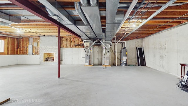 basement with gas water heater, heating unit, and electric panel