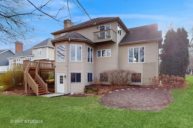 rear view of house featuring a wooden deck, a balcony, and a lawn