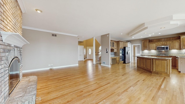 unfurnished living room with crown molding, a brick fireplace, and light hardwood / wood-style flooring