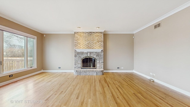 unfurnished living room with light hardwood / wood-style flooring, crown molding, and a fireplace