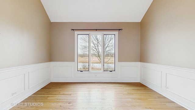 unfurnished room with lofted ceiling and light hardwood / wood-style flooring