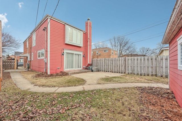 back of property with a yard and central air condition unit