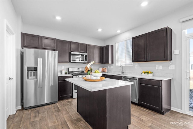 kitchen featuring sink, hardwood / wood-style floors, a center island, and appliances with stainless steel finishes